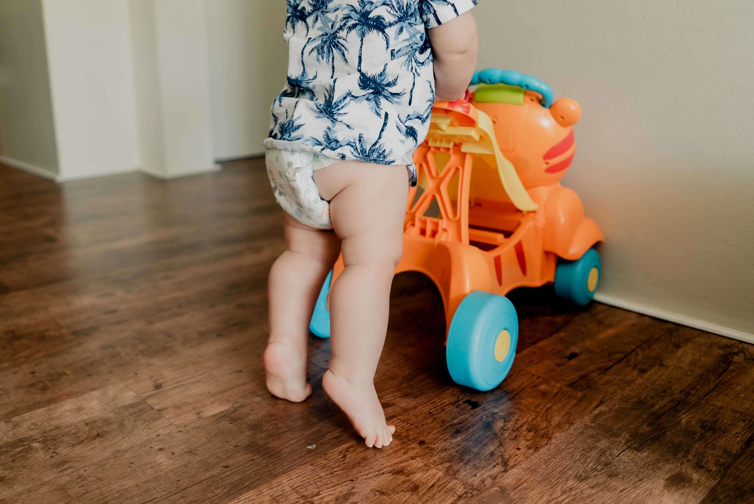 birthday films and photos: close-up of baby's legs pushing a baby walker