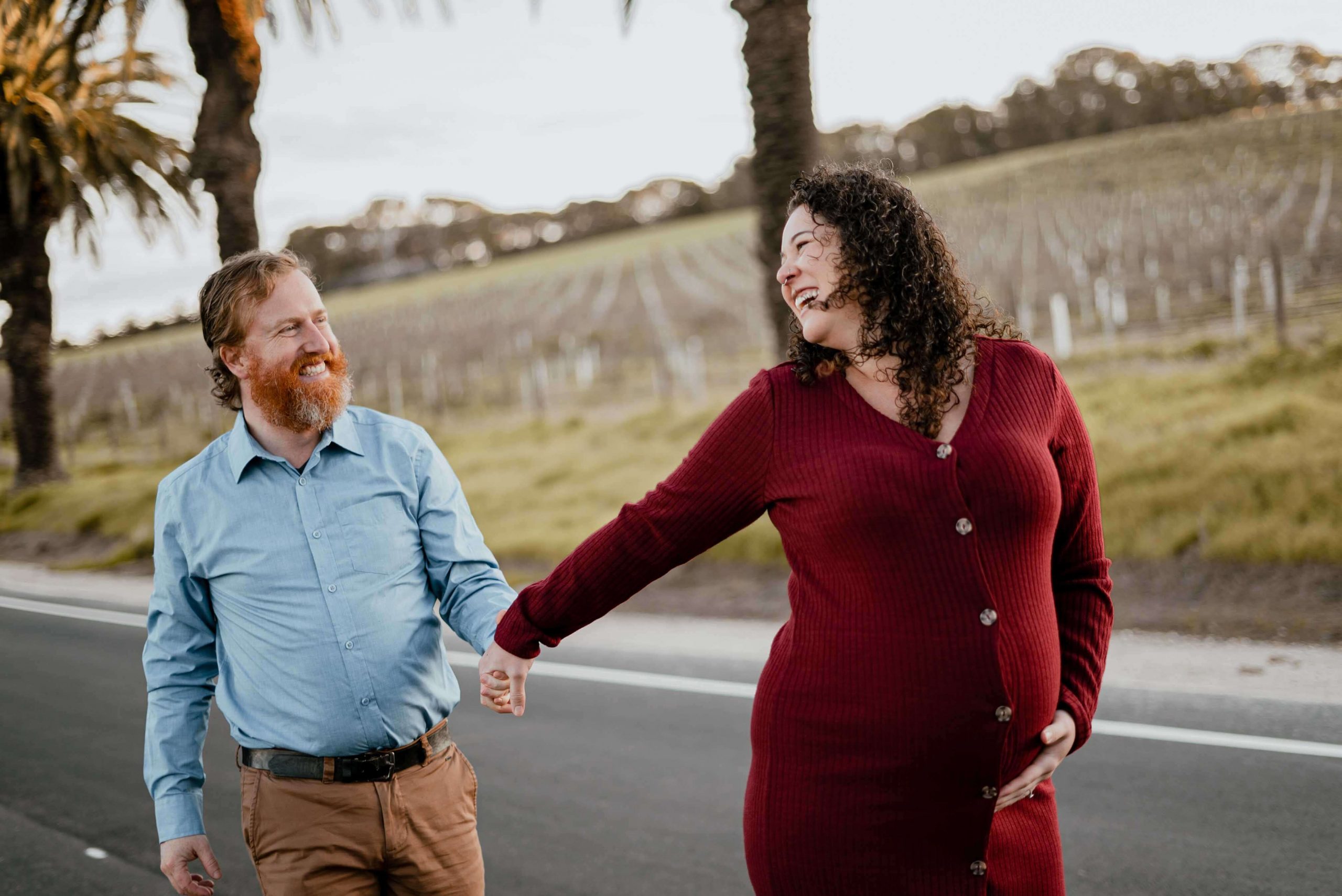 maternity films and photos: pregnant women walking holding hands with her husband and leading the way