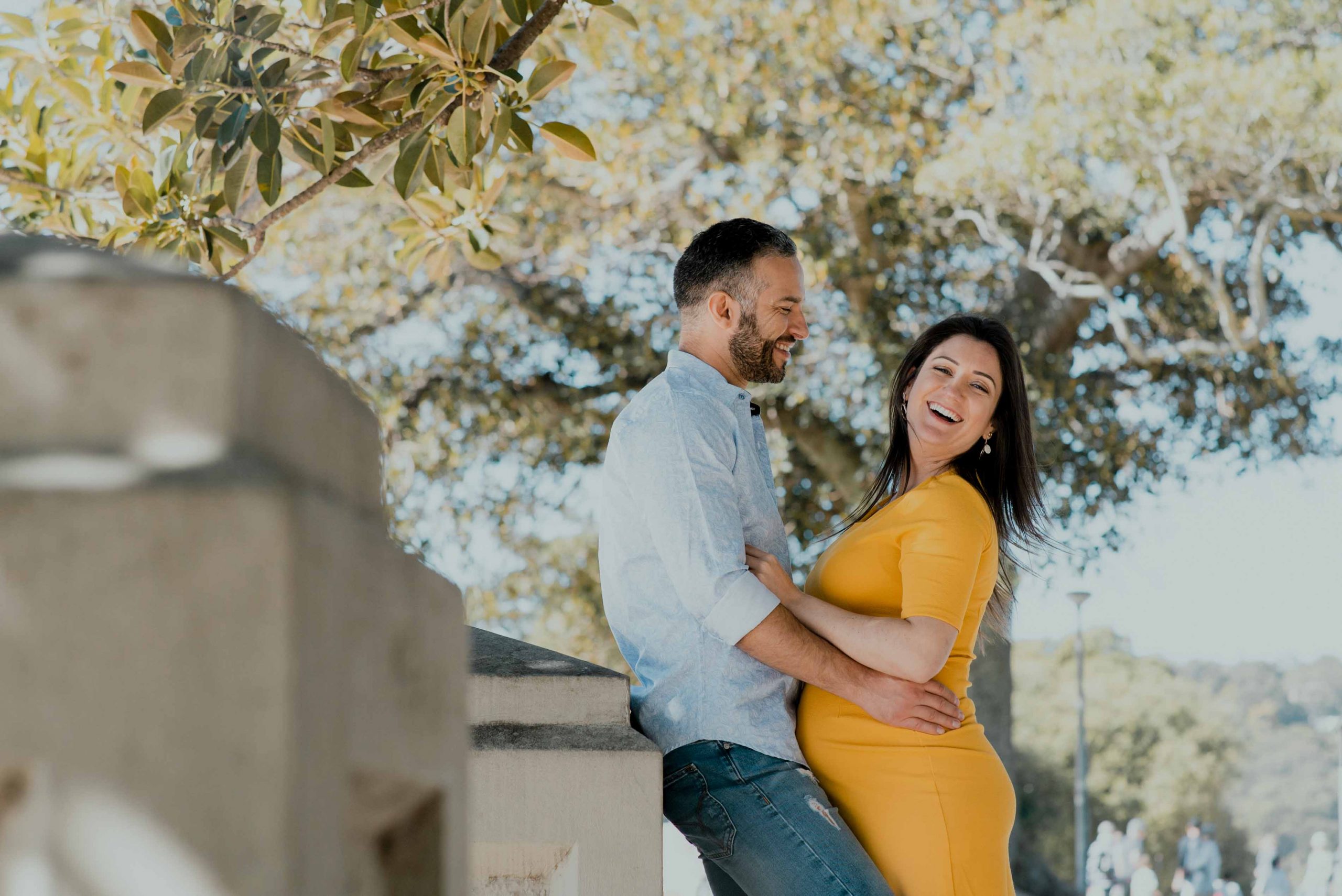 maternity films and photos: parents to be in a park, hugging each other