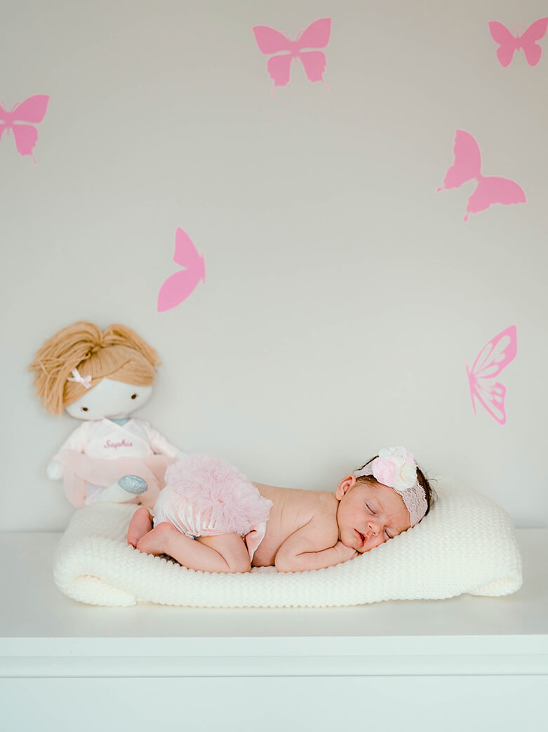 newborn films and photos: baby girl wearing pink pants and sleeping with belly down