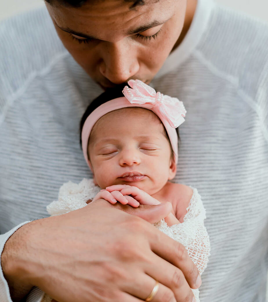 newborn films and photos: daddy holding sleeping newborn and kissing her head